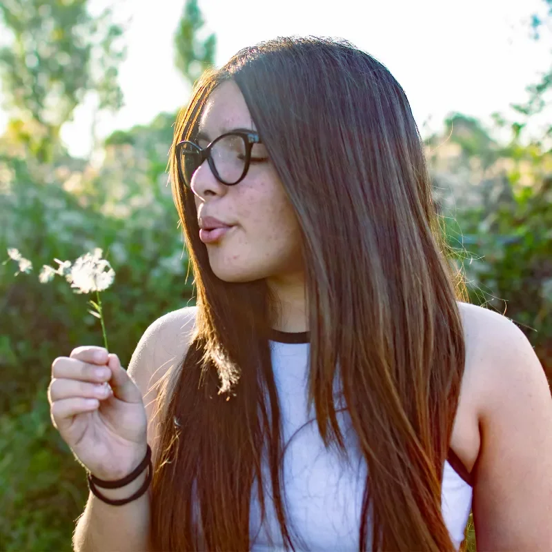 a young adult with dandelion