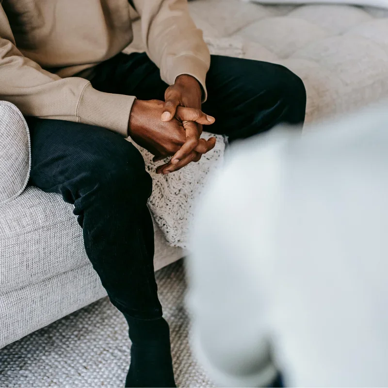 A person is sitting on a couch in front of their therapist.