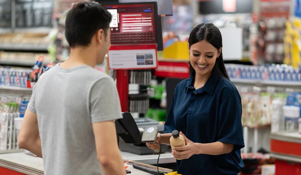 Customer speaks with a cashier at a store checkout.