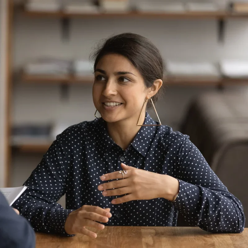 A woman is smiling while having a conversation.