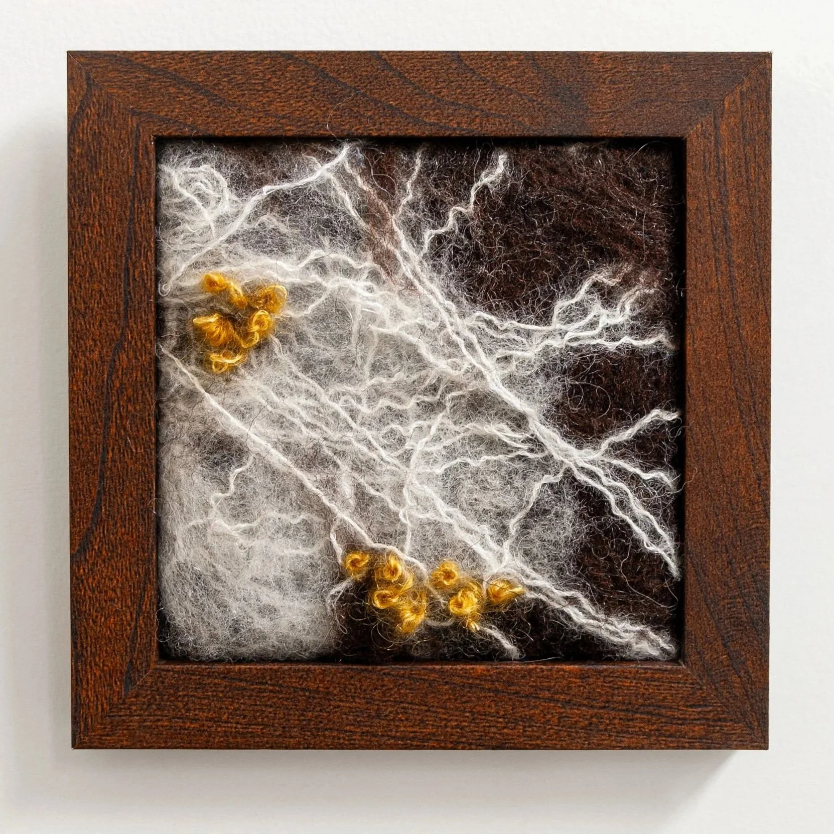 white fibers with yello accents to represent fungi framed fiber art
