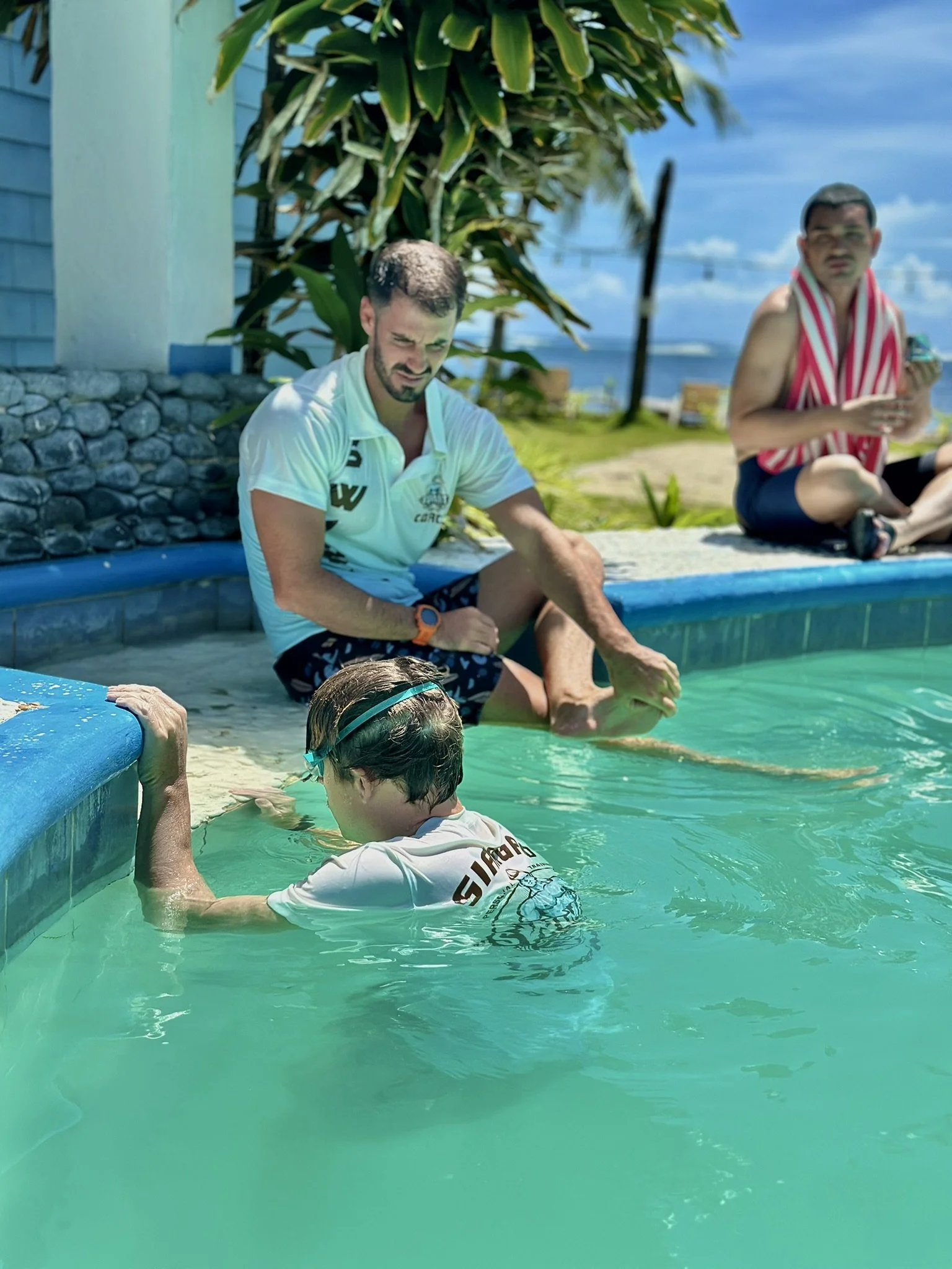 the coach sitting down next to the swimmer, explaining him what is gonna be the next set
