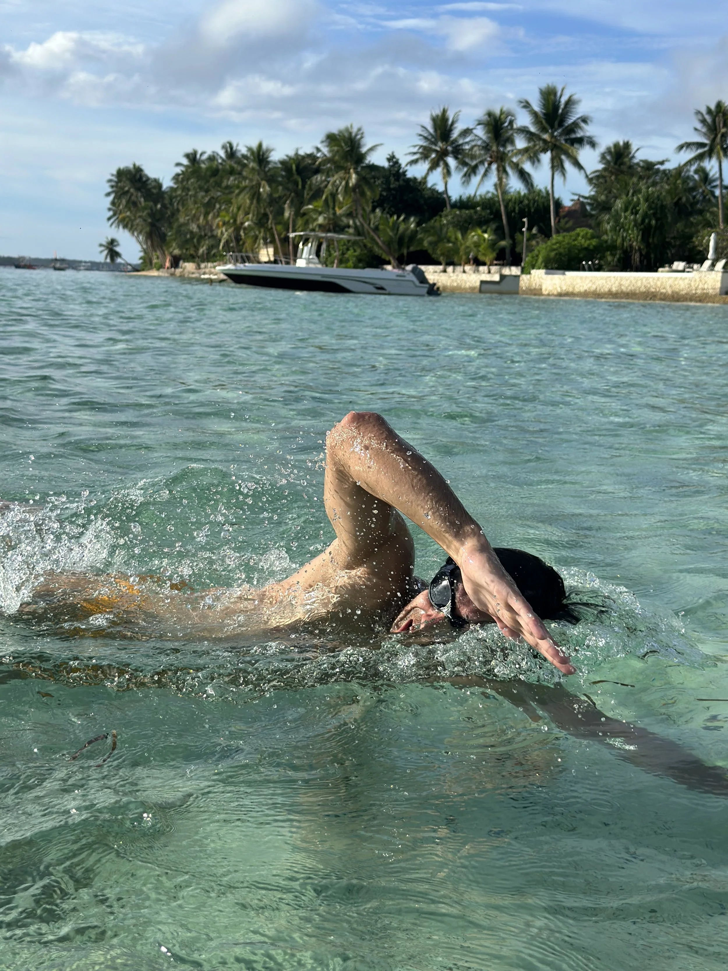 man swimming in the ocean at sunset in siargao