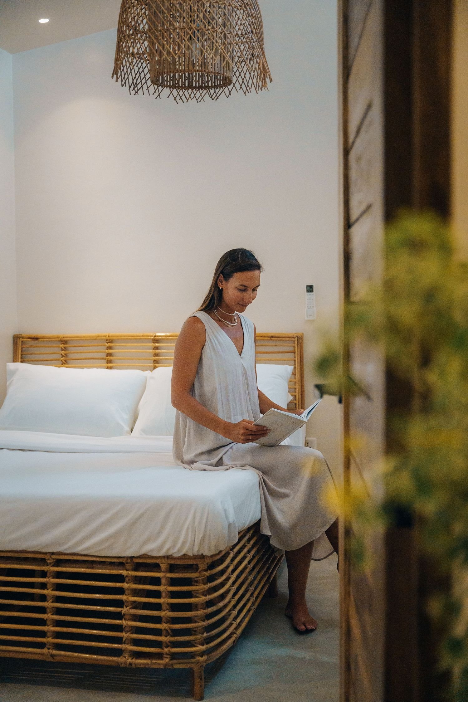 woman sitting on the bed reading a book at guava house