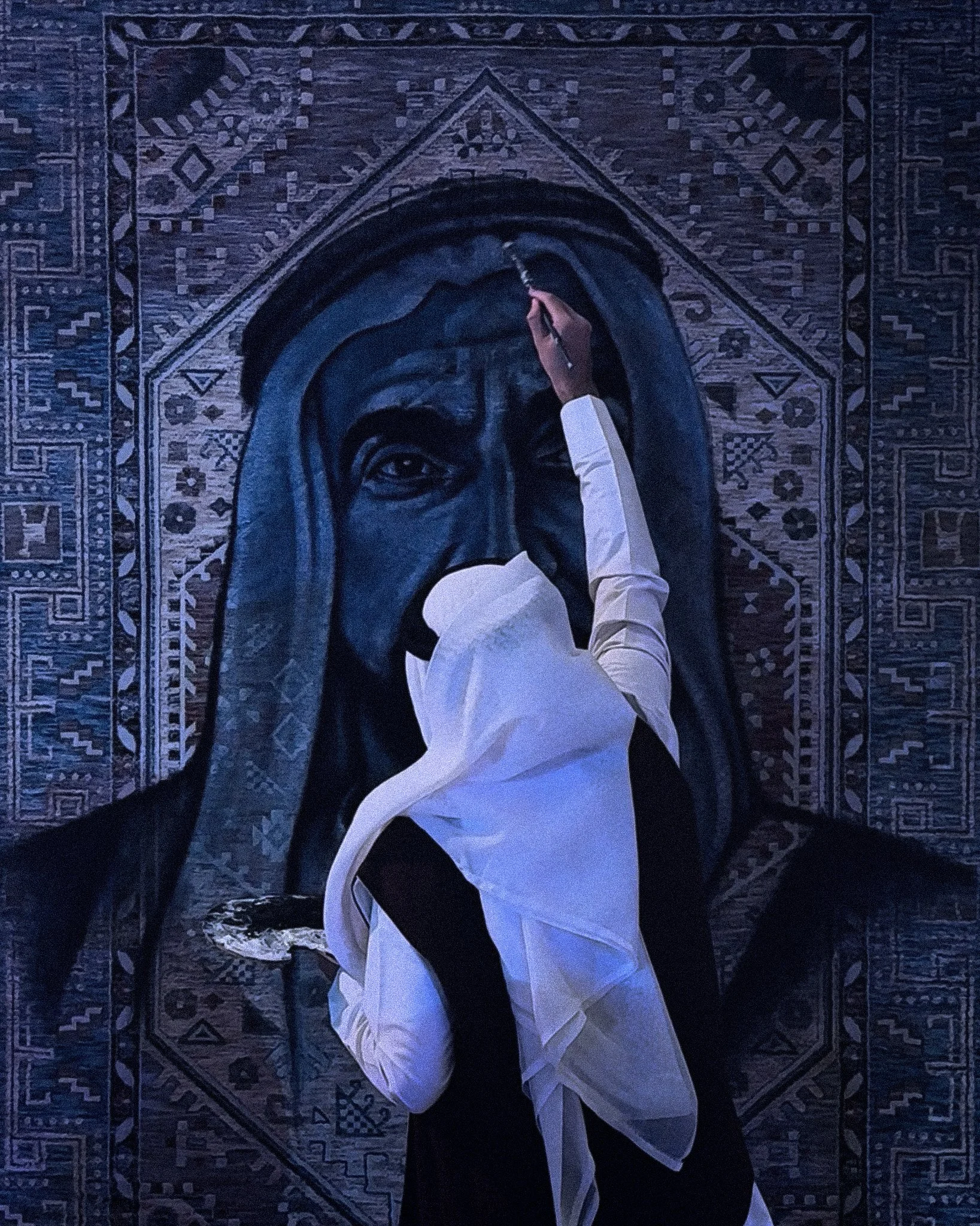 A person dressed in white, painting a portrait of a man with a beard and traditional head covering on a wall or large canvas, featuring a thoughtful expression and detailed background designs.