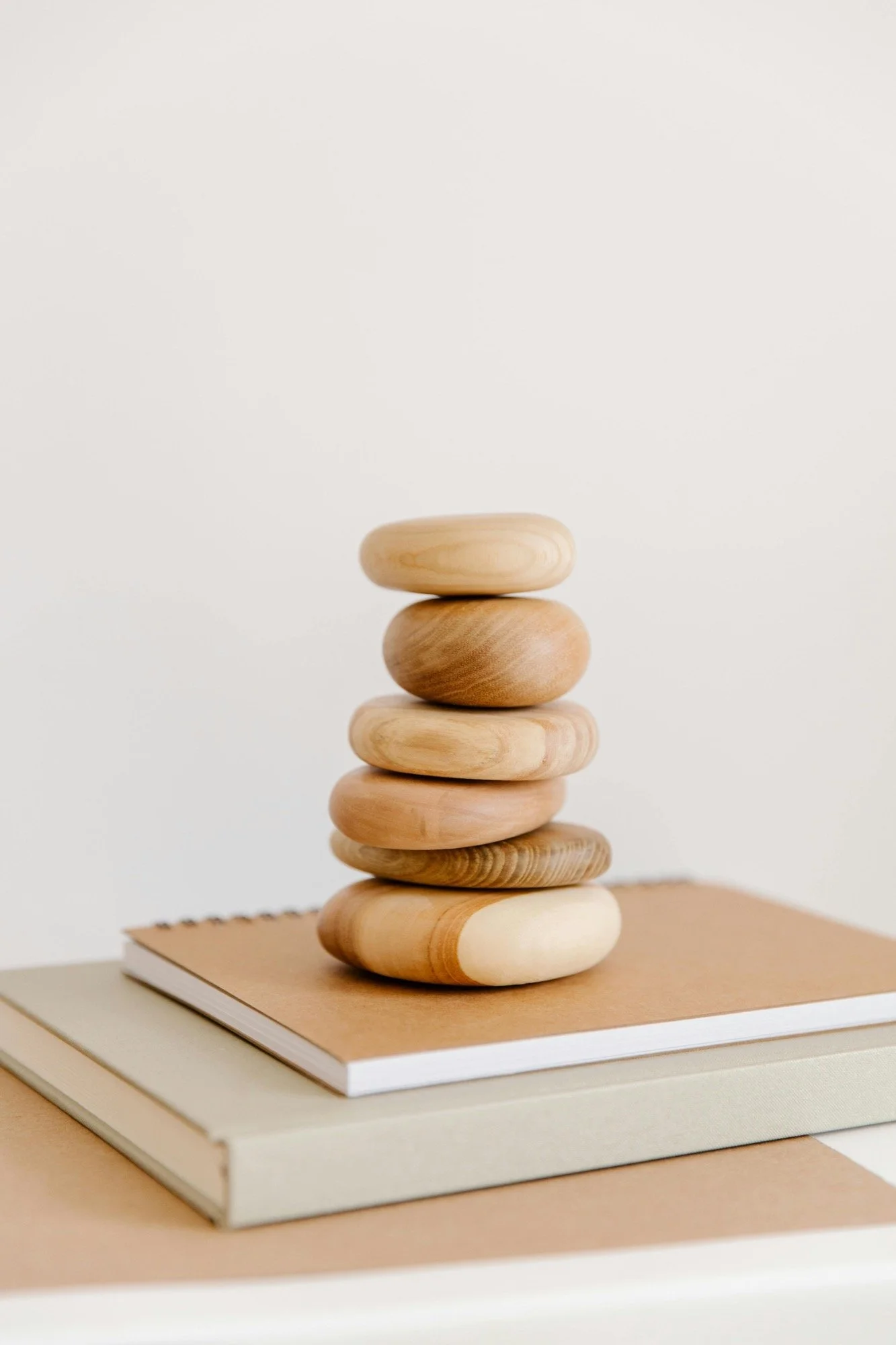 Stack of wooden pebbles on top of a notebook