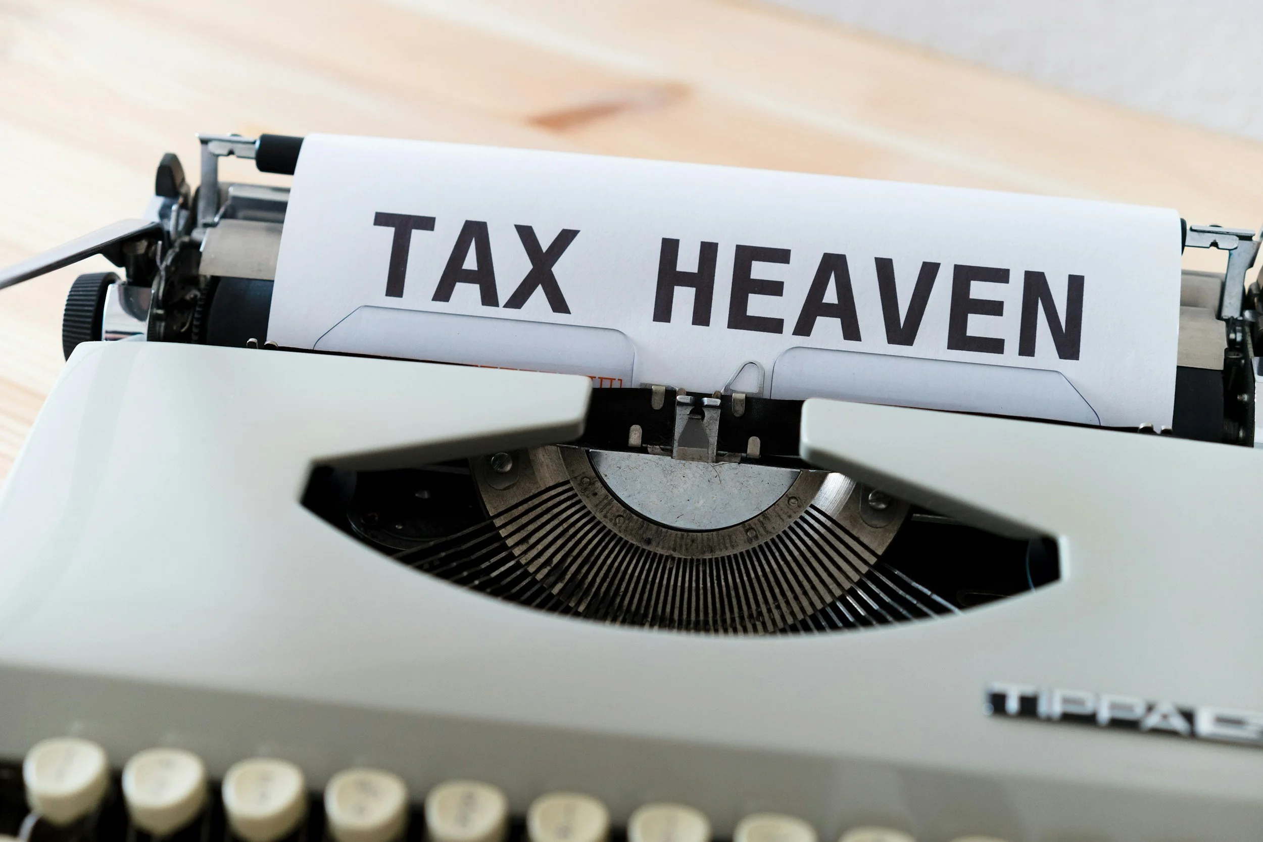 A typewriter with a paper that reads 'TAX HEAVEN' in large, bold letters.
