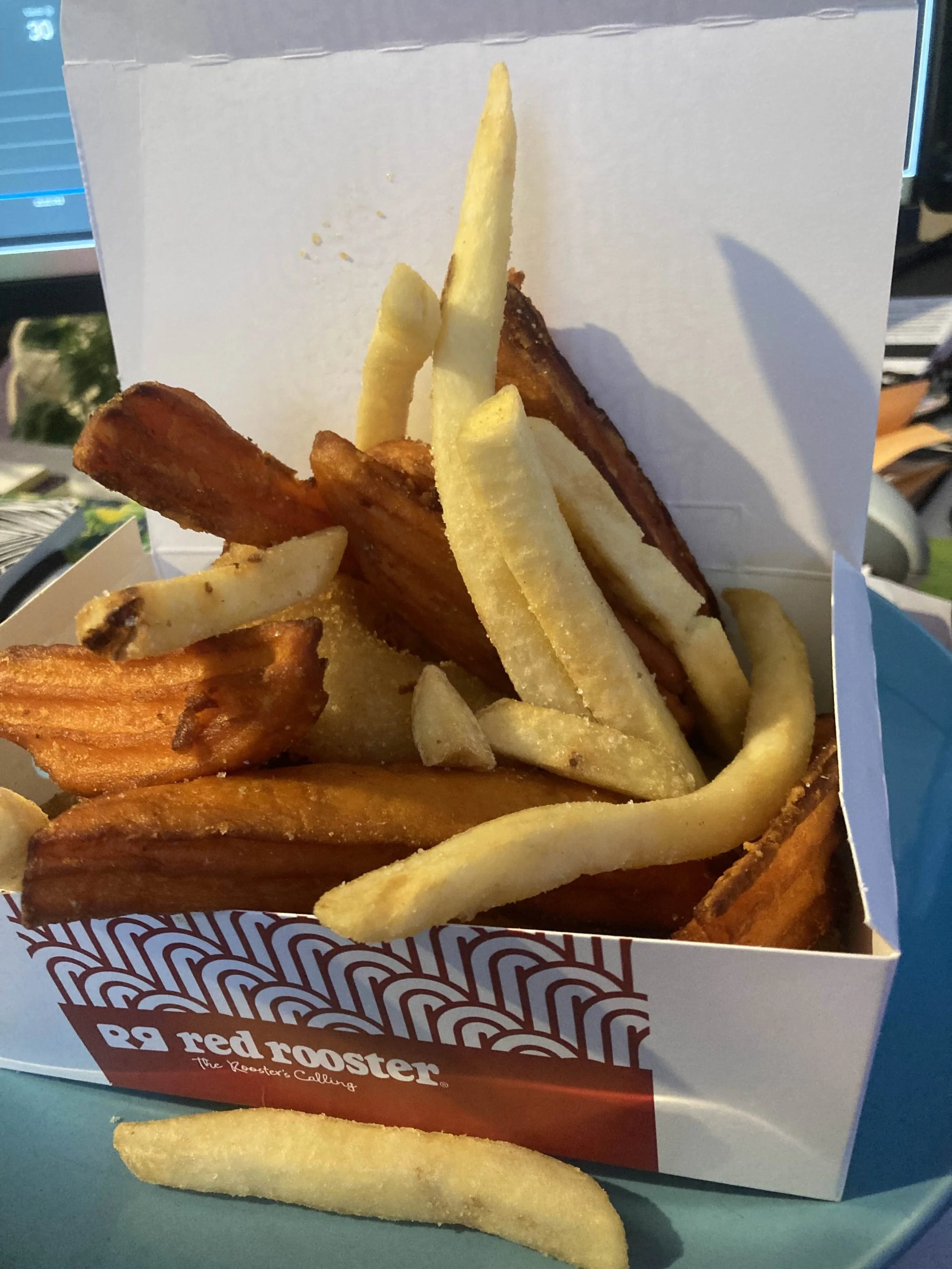 A OVERFLOWING BOX OF AUSTRALIAN RED ROOSTER WEDGES AND CHIPS