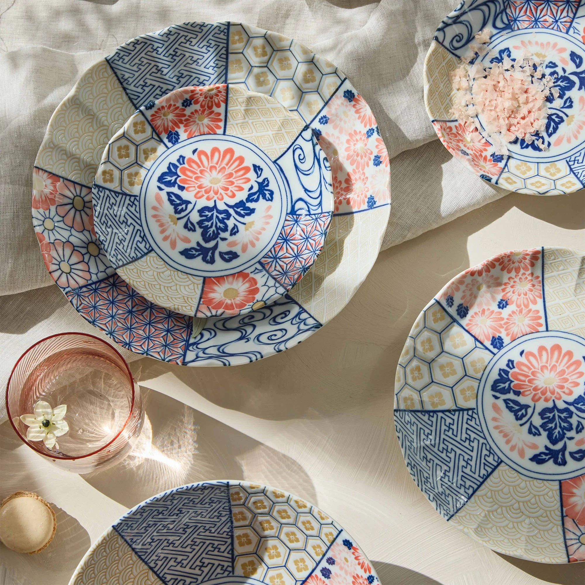 Tokyo Design Studio - Japanese porcelain plates with traditional blue, white and coral floral patterns arranged on a light table setting