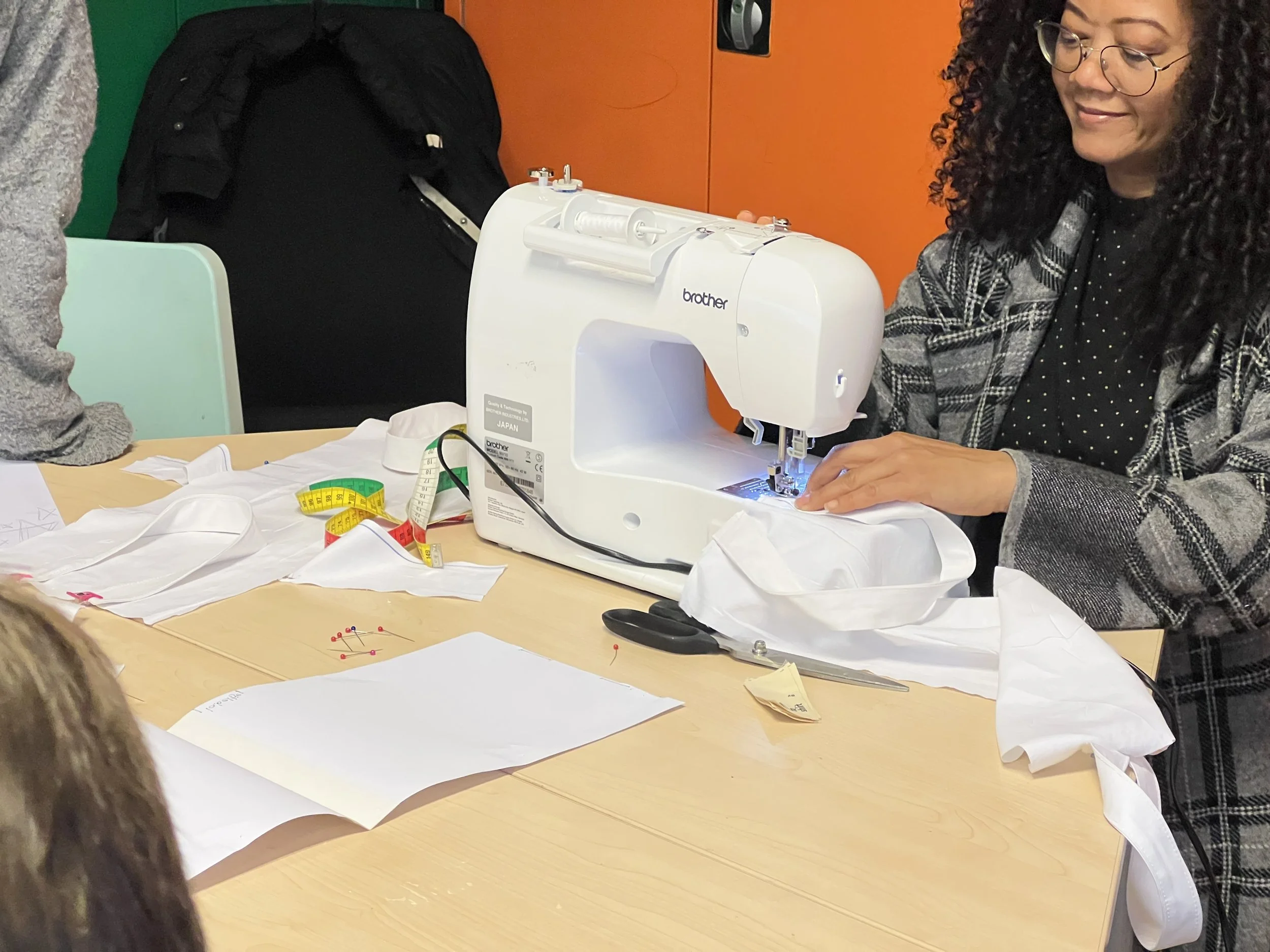 Charlotte tijdens de workshop achter naaimachine.jpeg