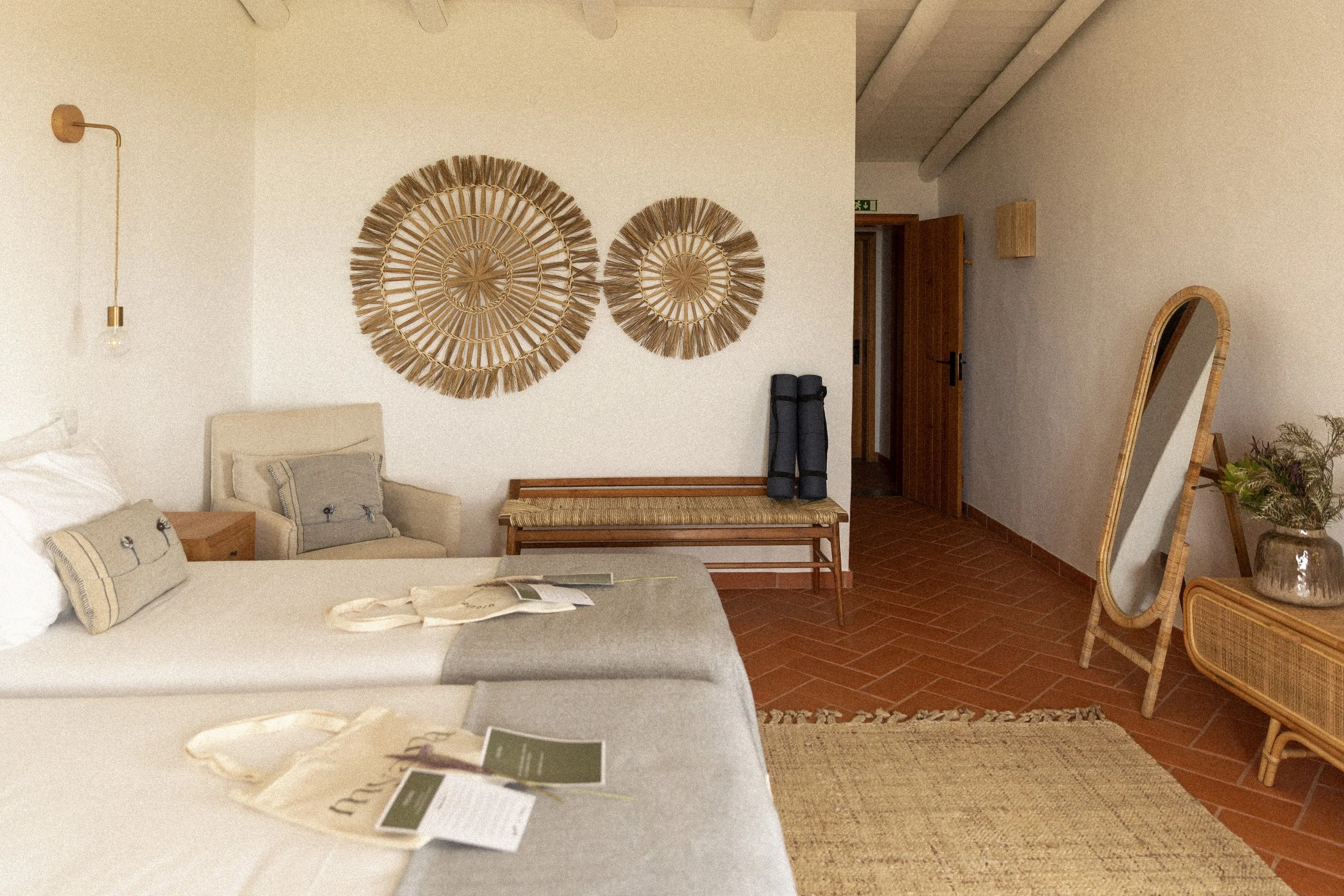 Innenraum mit Wanddekoration aus Naturmaterialien, Sofa, Spiegel, Holzmöbel und Teppich.