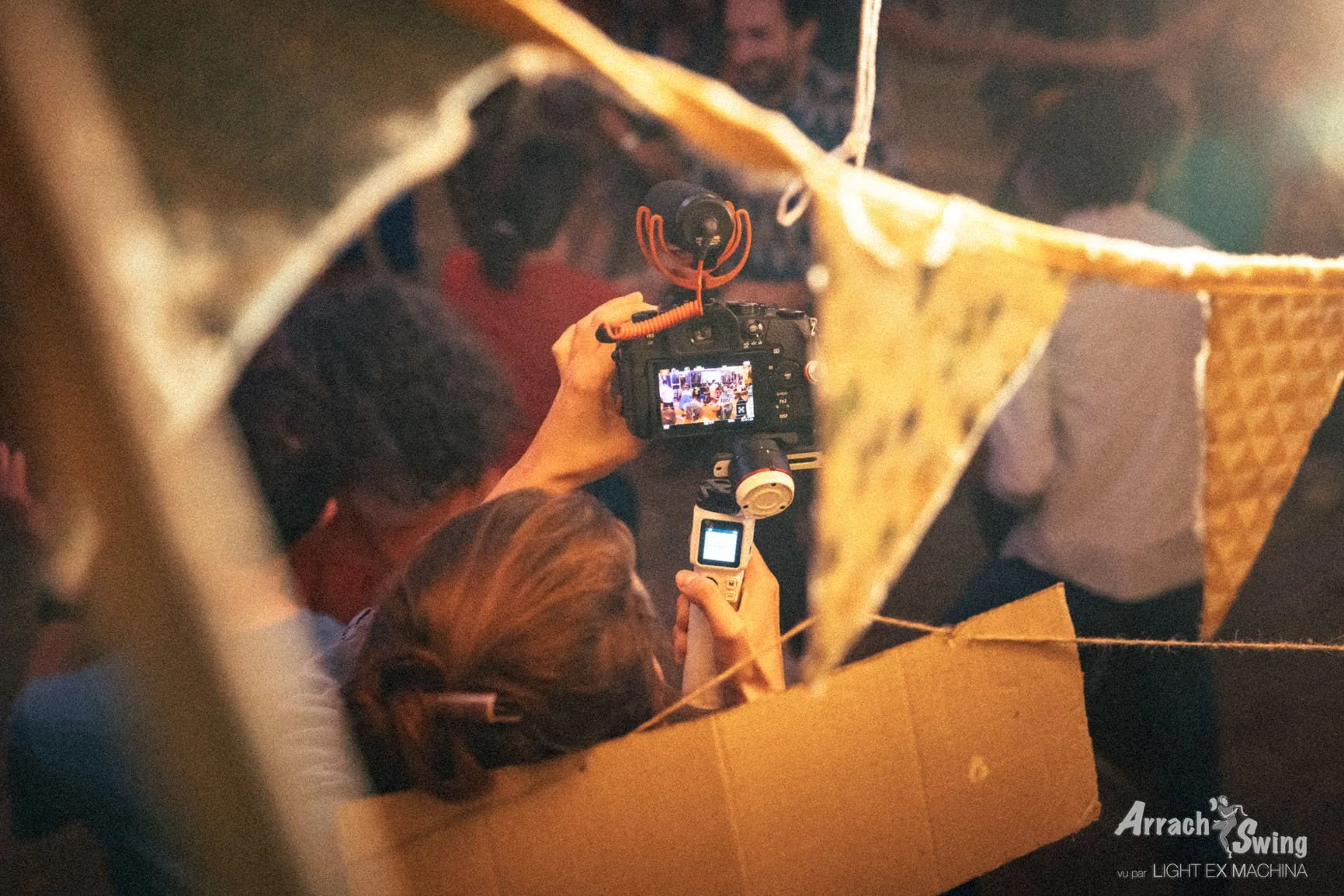 photo d'une vidéaste de dos qui ajuste sa prise de vue