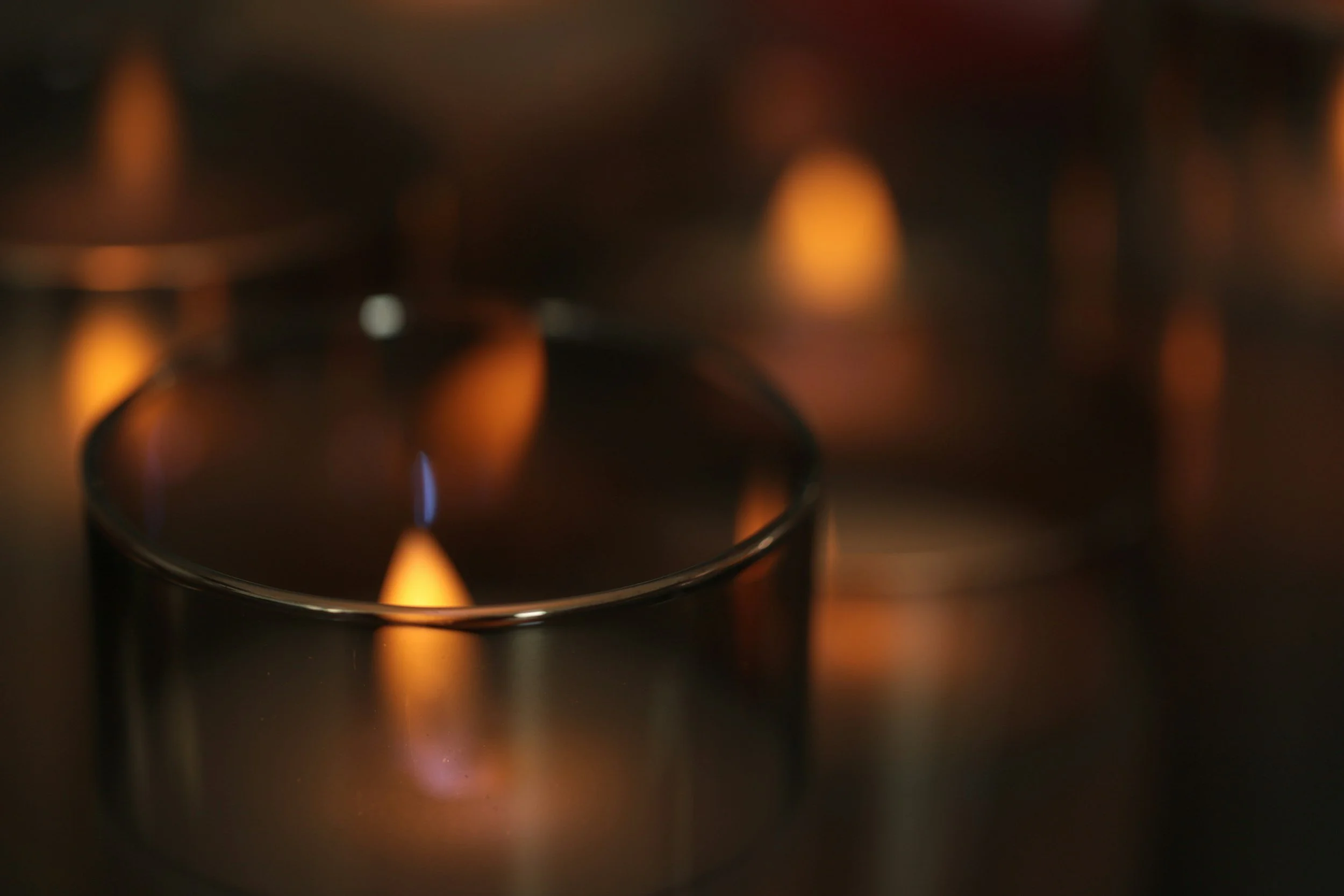 Close-up of a gas stove burner with a blue flame burning.
