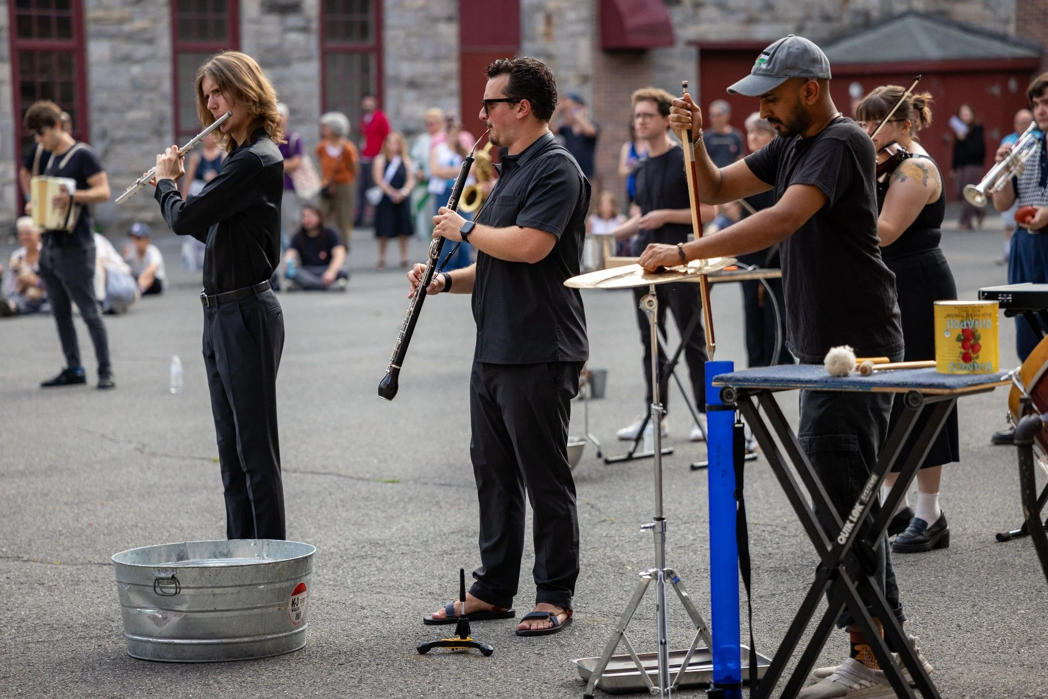 Michael Isaac Ripple playing English horn with fellow musicians during an outdoor performance.