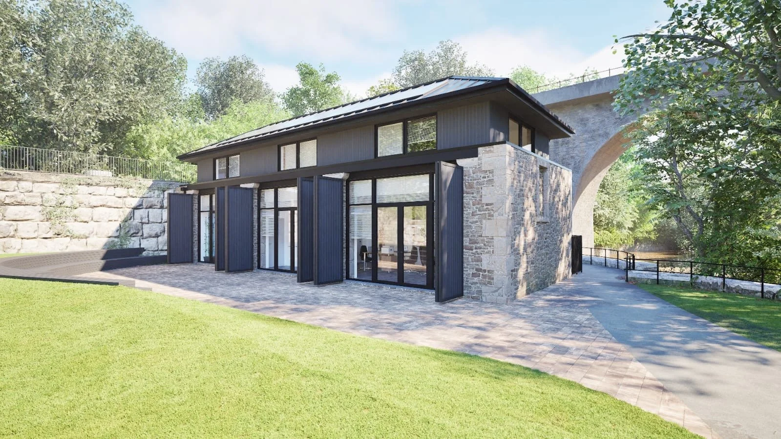 view of spylaw park building in colinton as viewed from park with black metal roof and large openings.