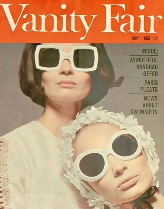 Cover of Vanity Fair magazine from May 1965 featuring two women wearing large white sunglasses, one with short brown hair and the other with a headscarf and oversized sunglasses.