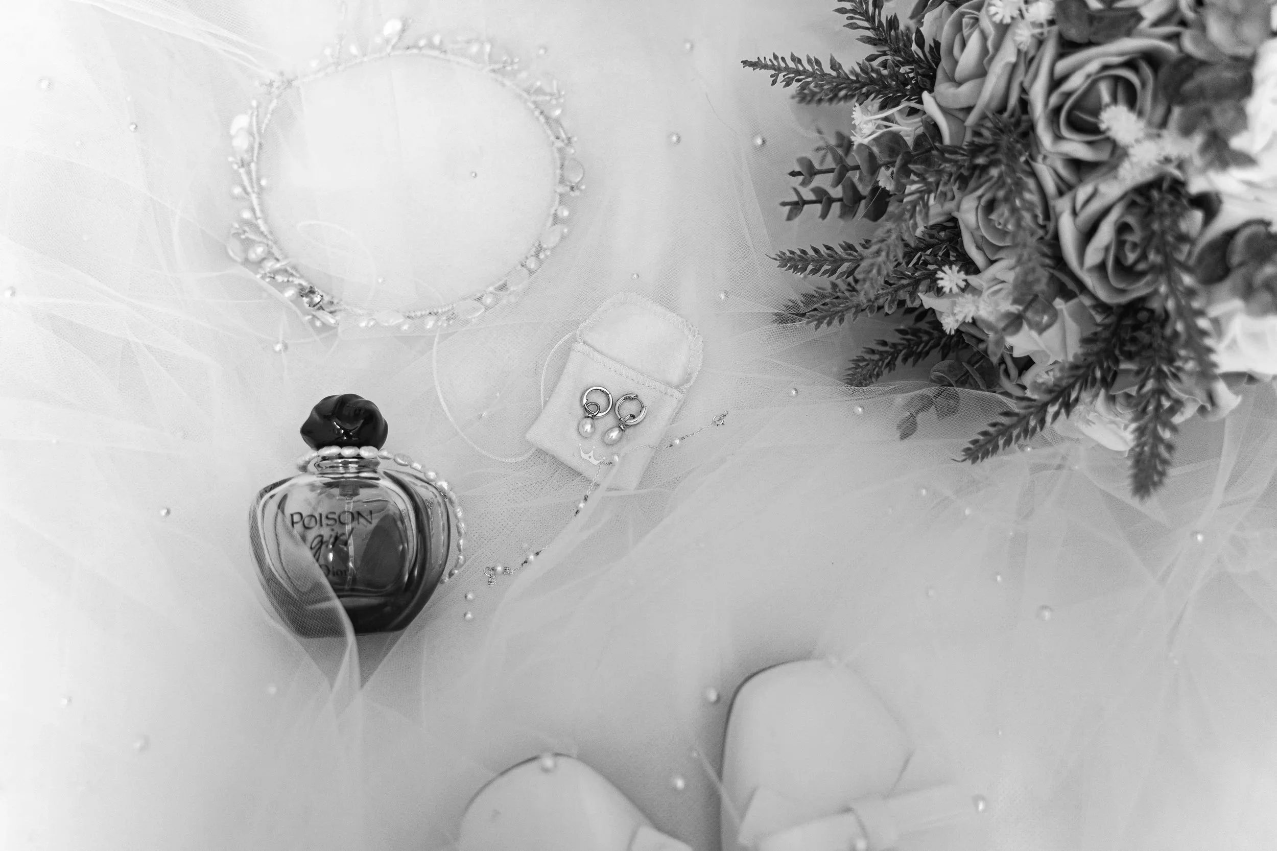 A man and woman dancing on a step in front of a building with large glass-paneled doors and potted topiary plants.