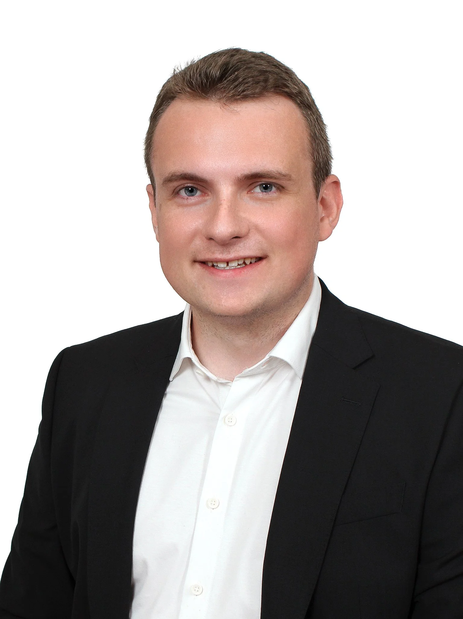 Porträt eines Mannes in einem schwarzen Sakko und weißem Hemd vor weißem Hintergrund