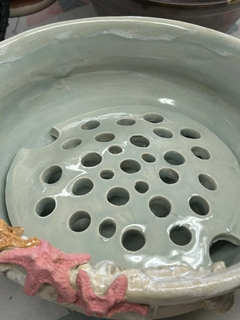 Ceramic bowl with holes and starfish decorations