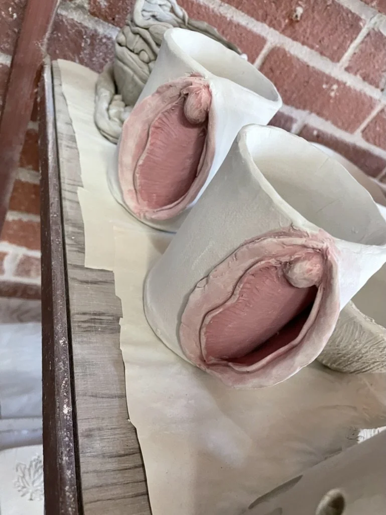 Handmade ceramic mugs with artistic feminine designs.