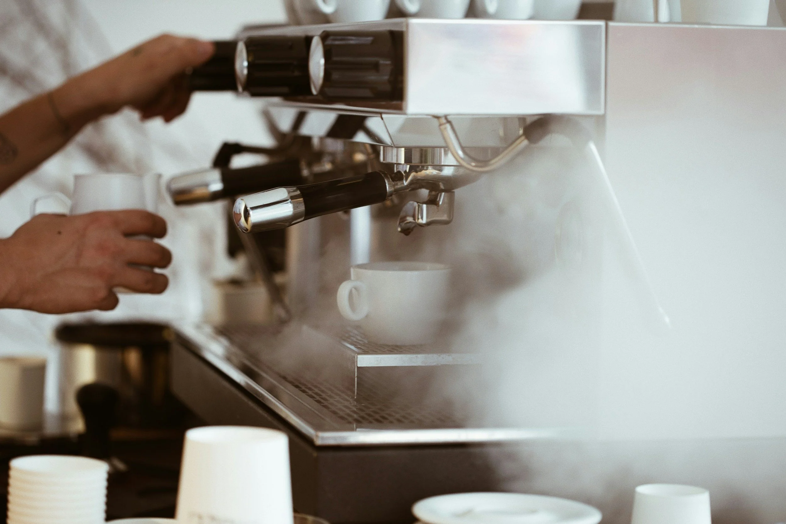 Close-up of an espresso machine pouring coffee into a glass cup.