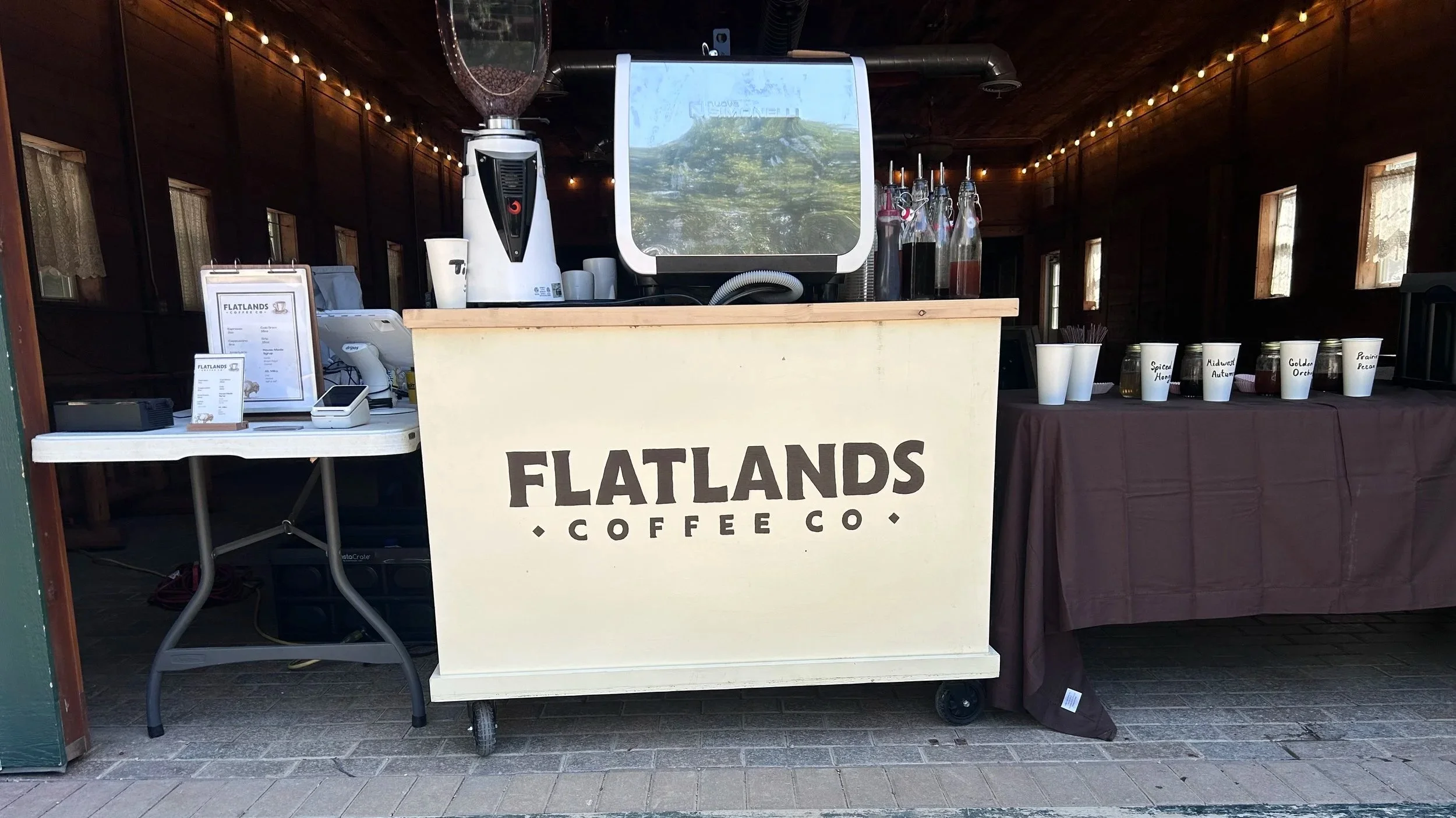 Flatlands Coffee cart setup under a canopy with staff holding drinks in Kansas City, Kansas