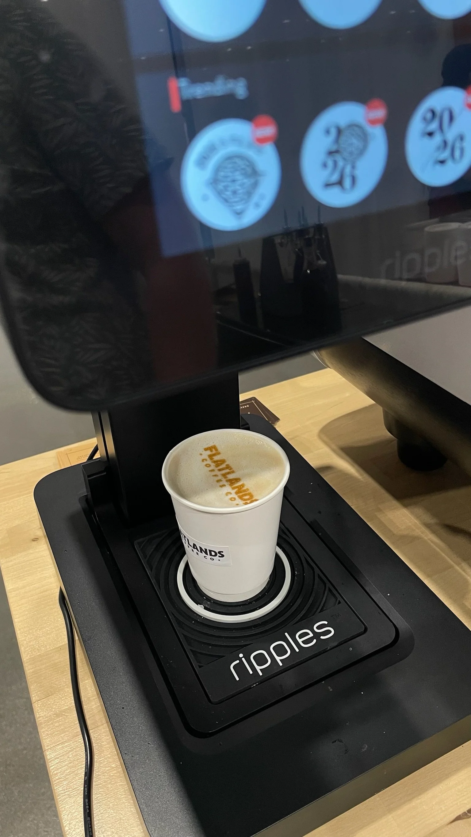 Latte art printer creating a logo print on a hot latte at the Flatlands cart
