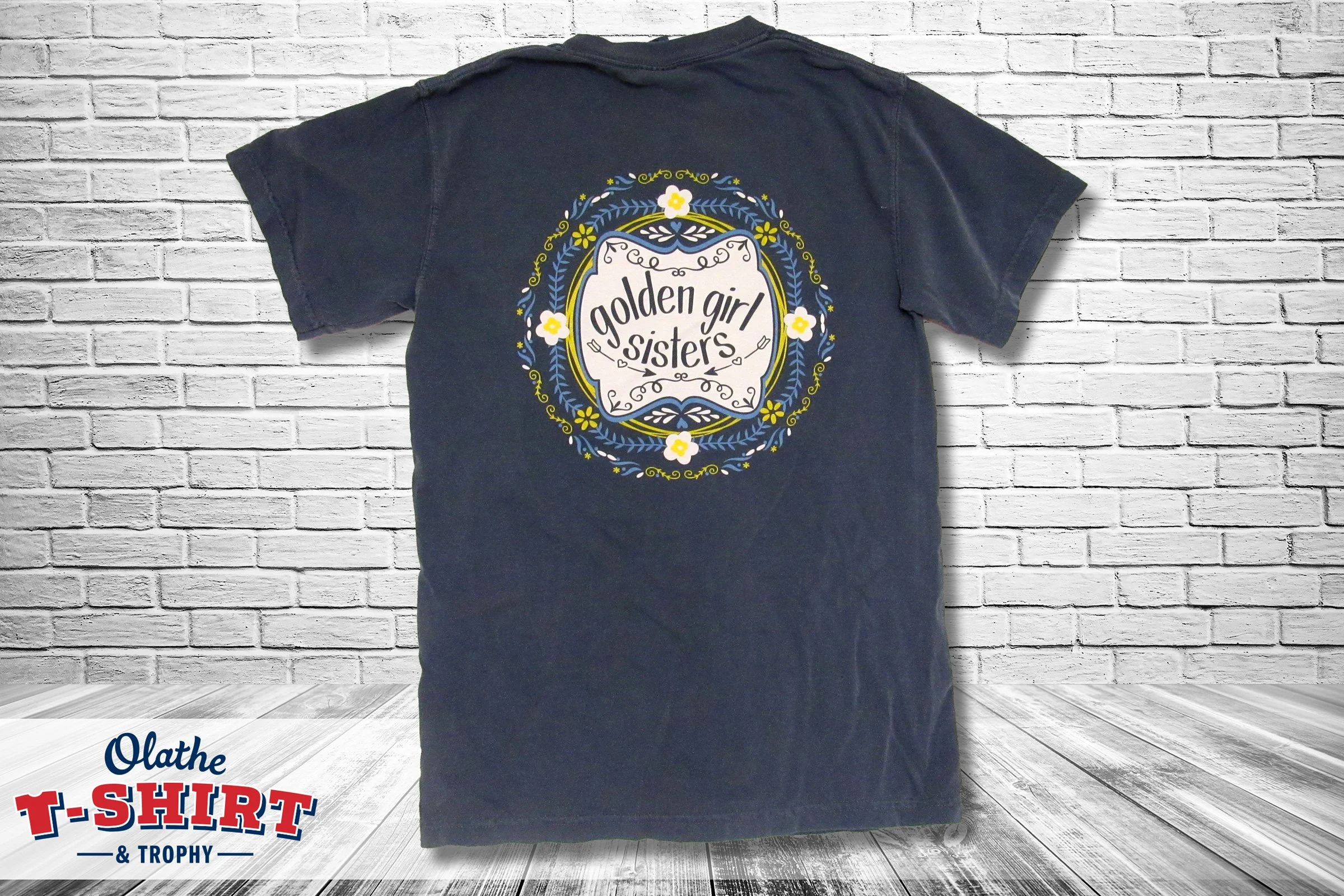 Black long-sleeve shirt with a colorful geometric chest graphic and white sleeve lettering.