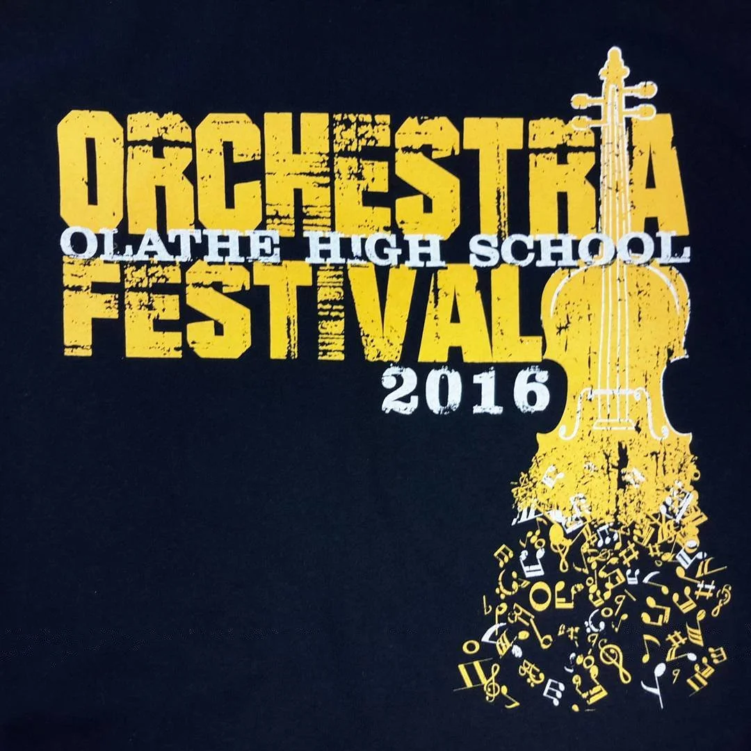 Black orchestra festival shirt with a violin illustration and musical notes.