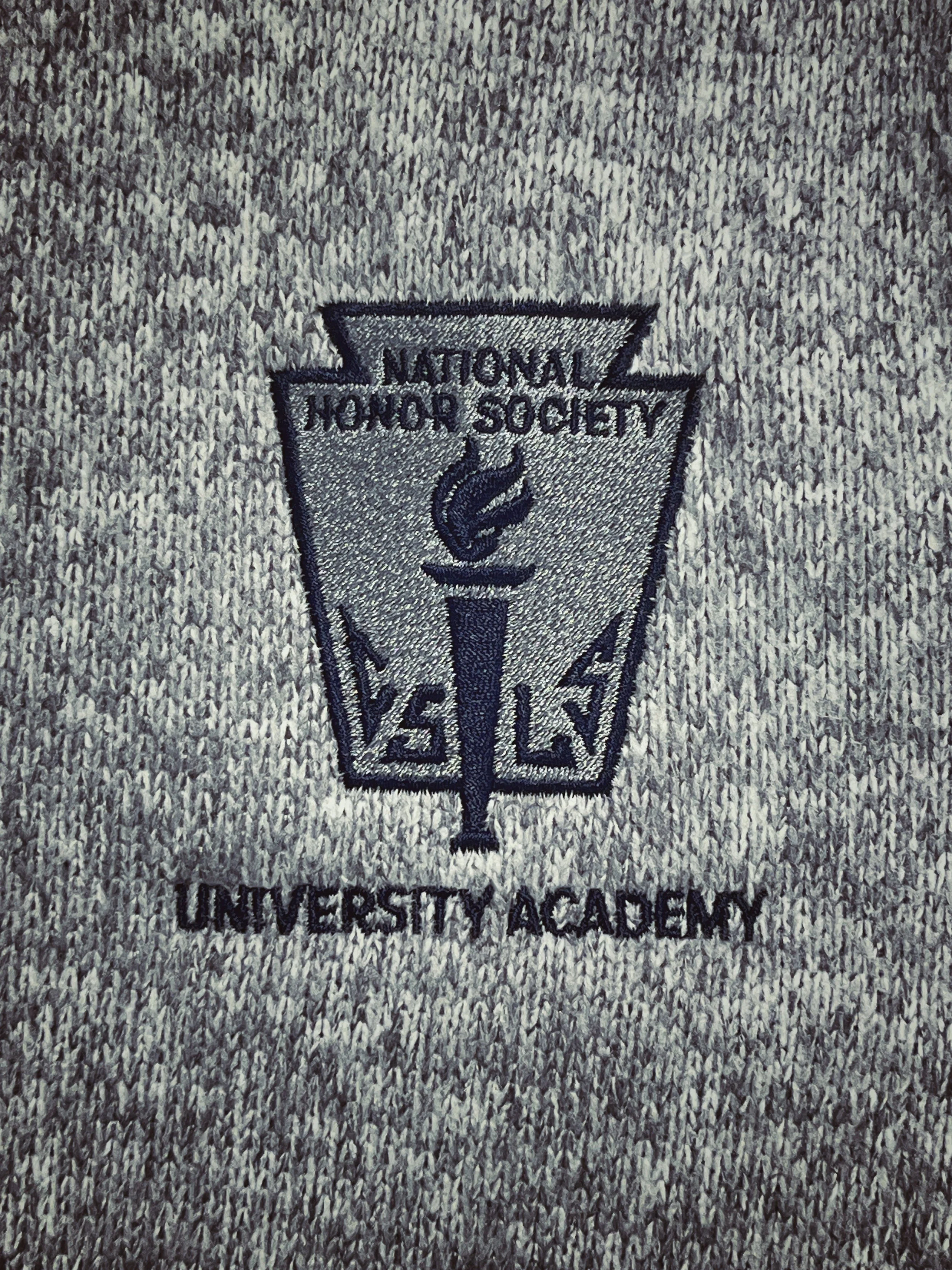 National Honor Society lettering and torch emblem embroidered on gray fabric.