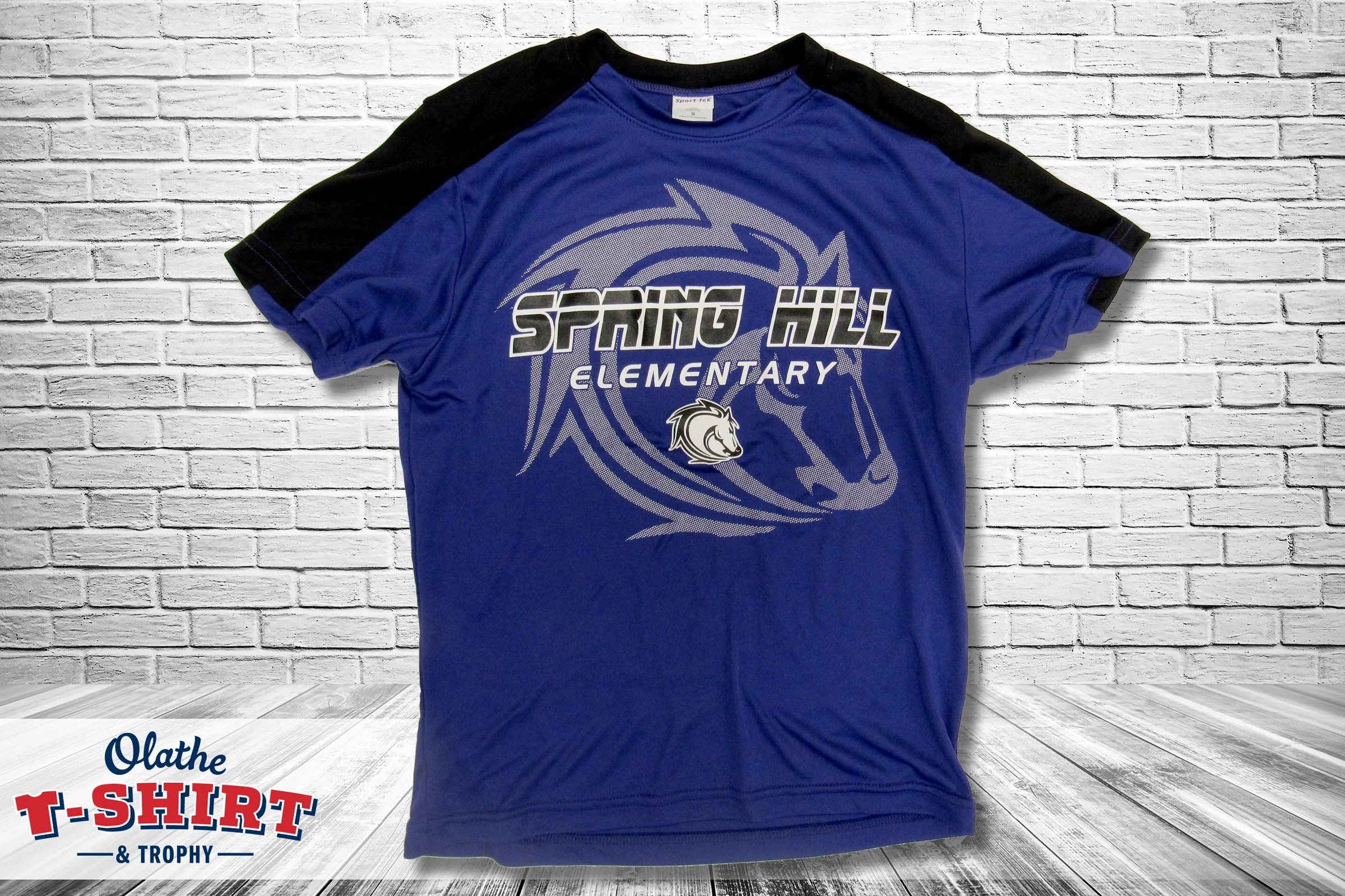 Blue and black school shirt with an animal mascot and lettering.