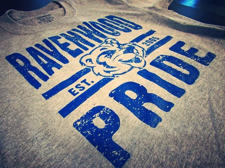 Gray T-shirt with blue text that reads 'RATHENOUSE PRIDE,' a tiger face logo, and 'EST. 2006'.
