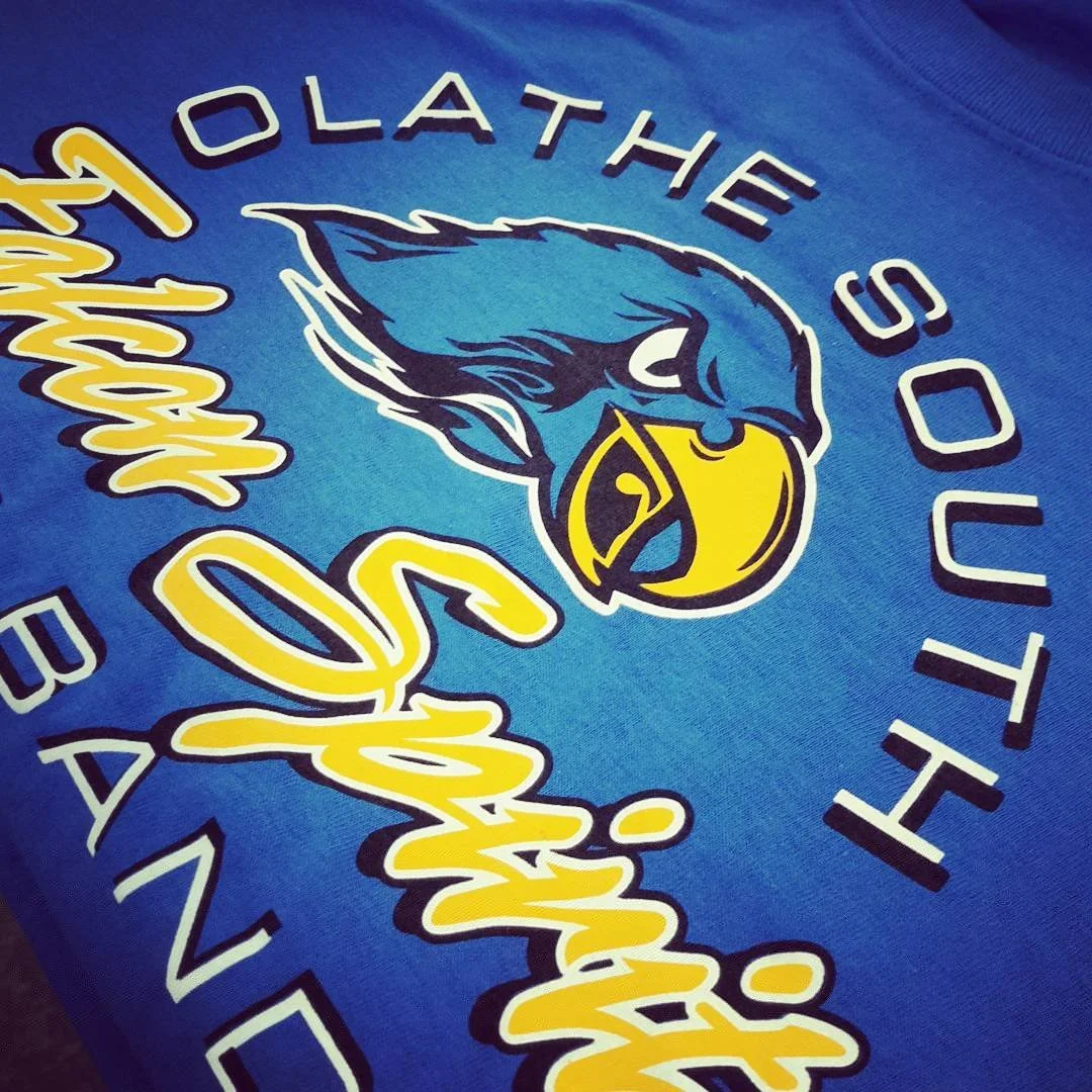 Close-up of a bird mascot and lettering printed on a blue T-shirt.