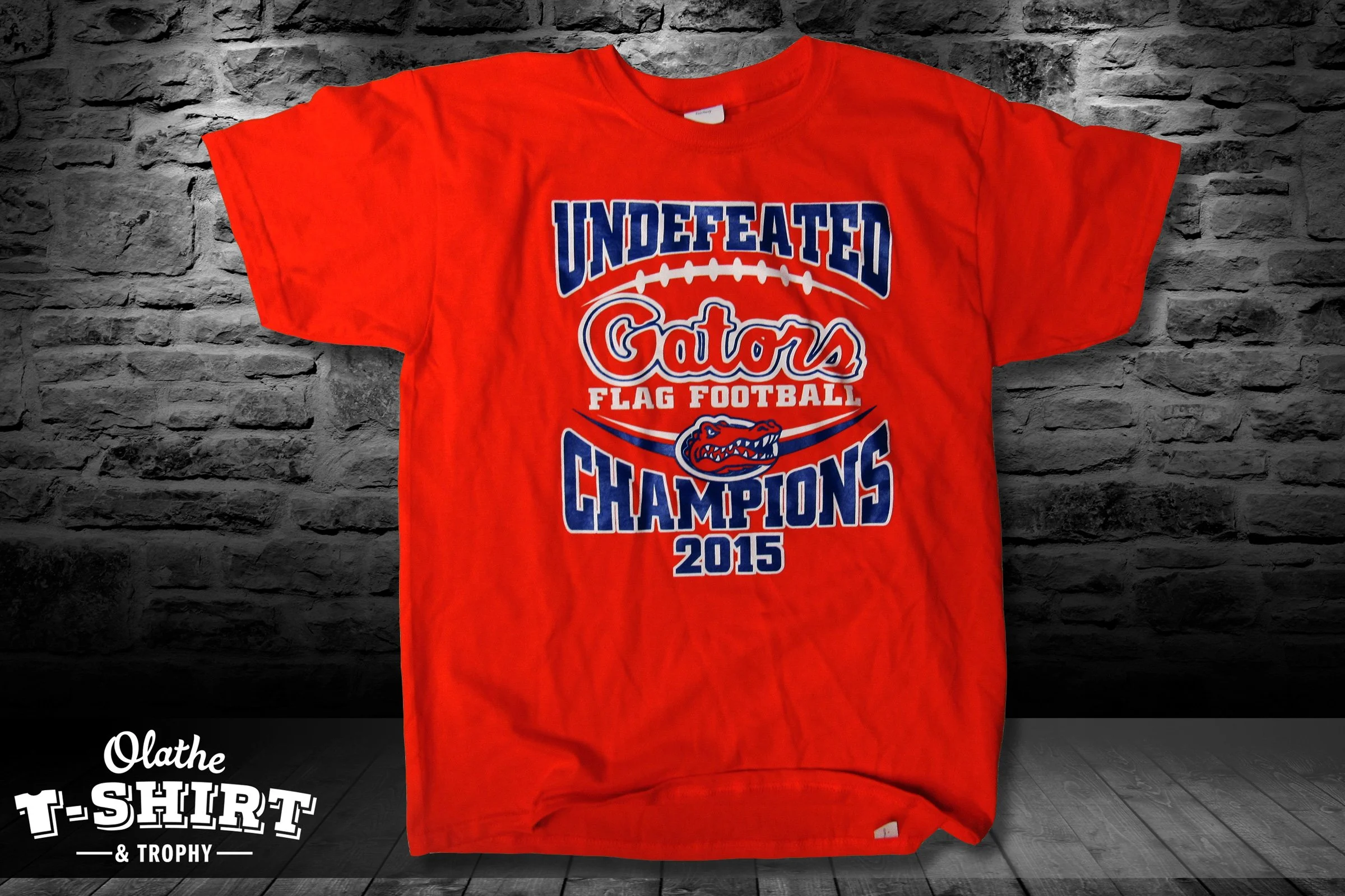 Red football shirt with blue and white team graphics and season lettering.