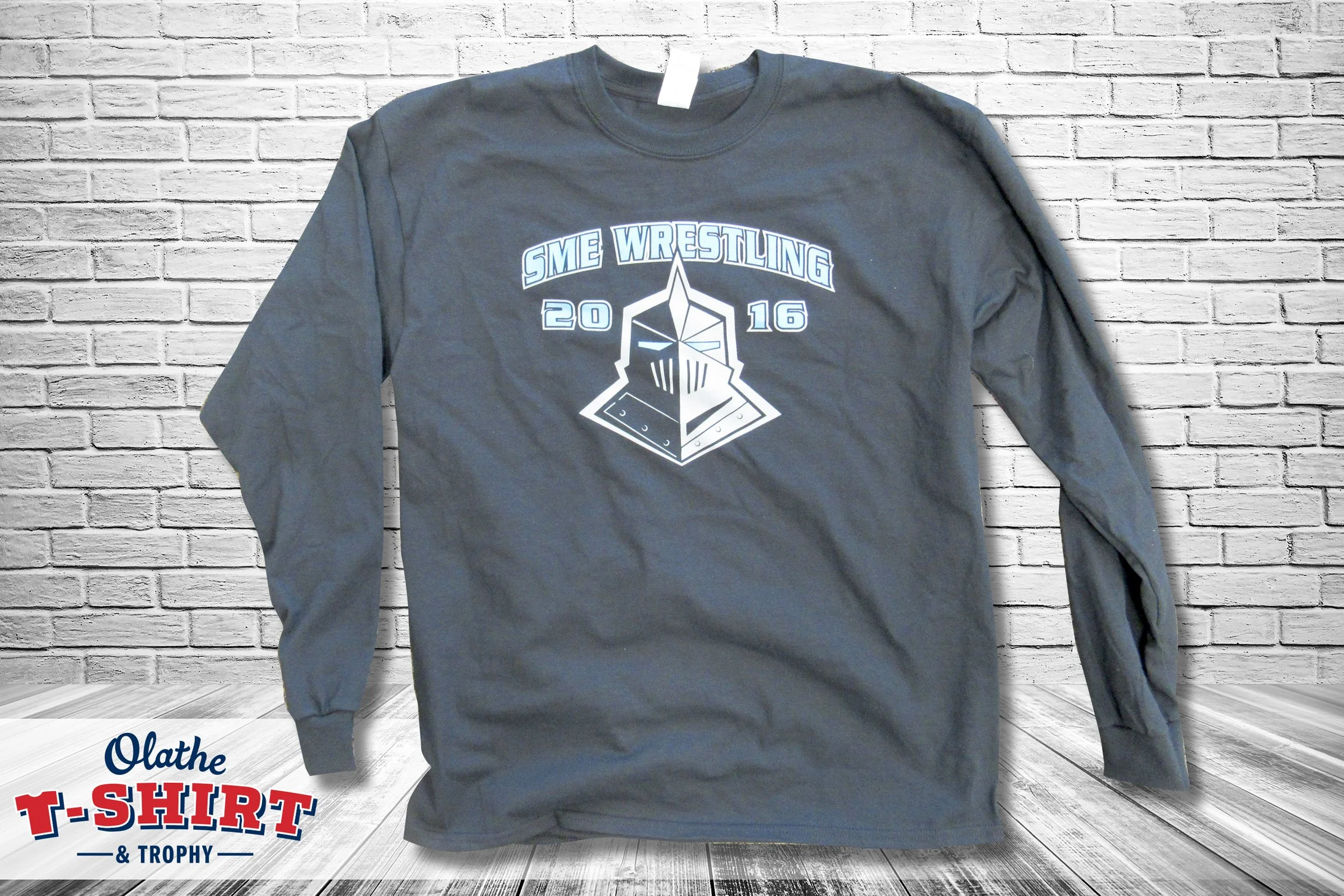 Gray long-sleeve wrestling shirt with a sports graphic and lettering.