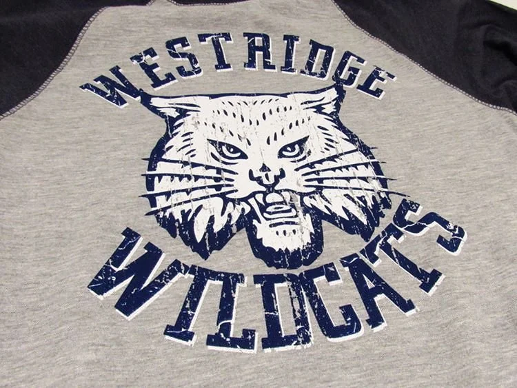 Gray and black shirt with a wildcat mascot and blue lettering.