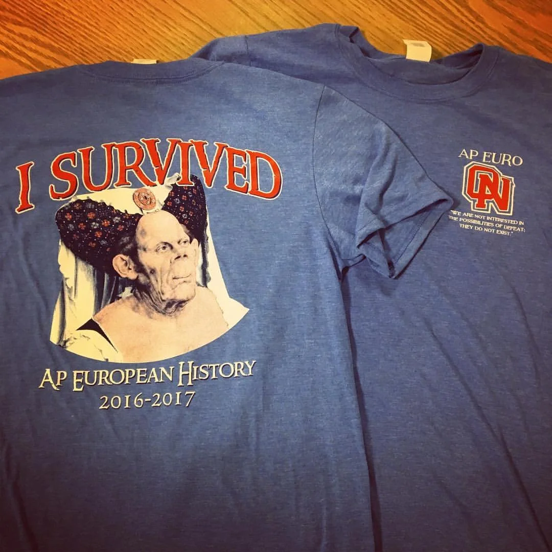 Blue T-shirts with graphic and text: one shirt has a photo of an elderly woman with a headscarf and the phrase "I SURVIVED AP EUROPEAN HISTORY 2016-2017", the other shirt has "AP EURO" and a logo with a quote about not being interested in possibiliti