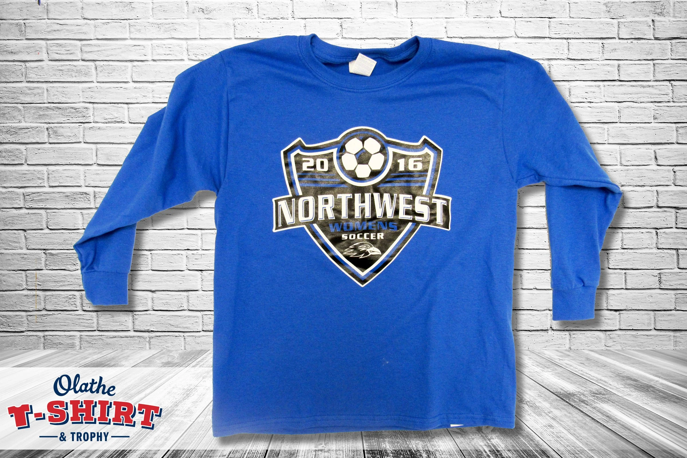 White and orange baseball-style Hawks Soccer shirt with a bird mascot.