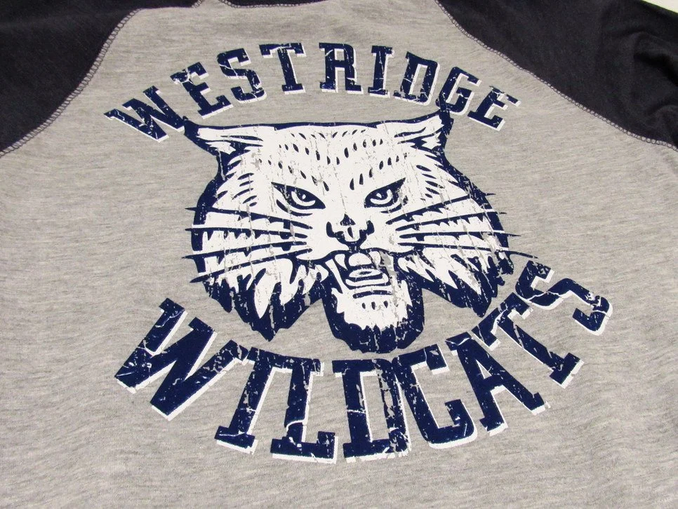Gray and black shirt with a distressed wildcat mascot design.
