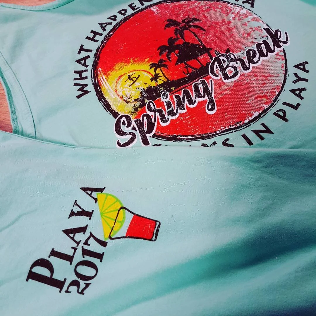 Light blue shirt with tropical vacation graphics and colorful lettering.