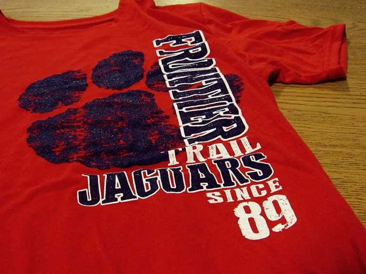 Red Jaguars shirt with a large black paw print and white lettering.