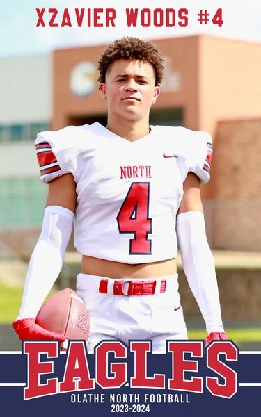 Football player in uniform holding a football on a field.