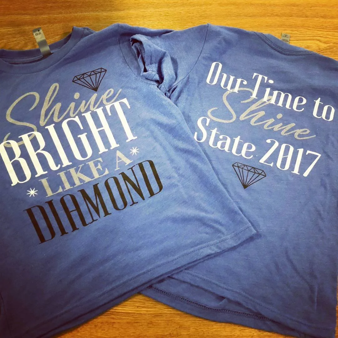 Blue T-shirts with diamond graphics and coordinating printed slogans.