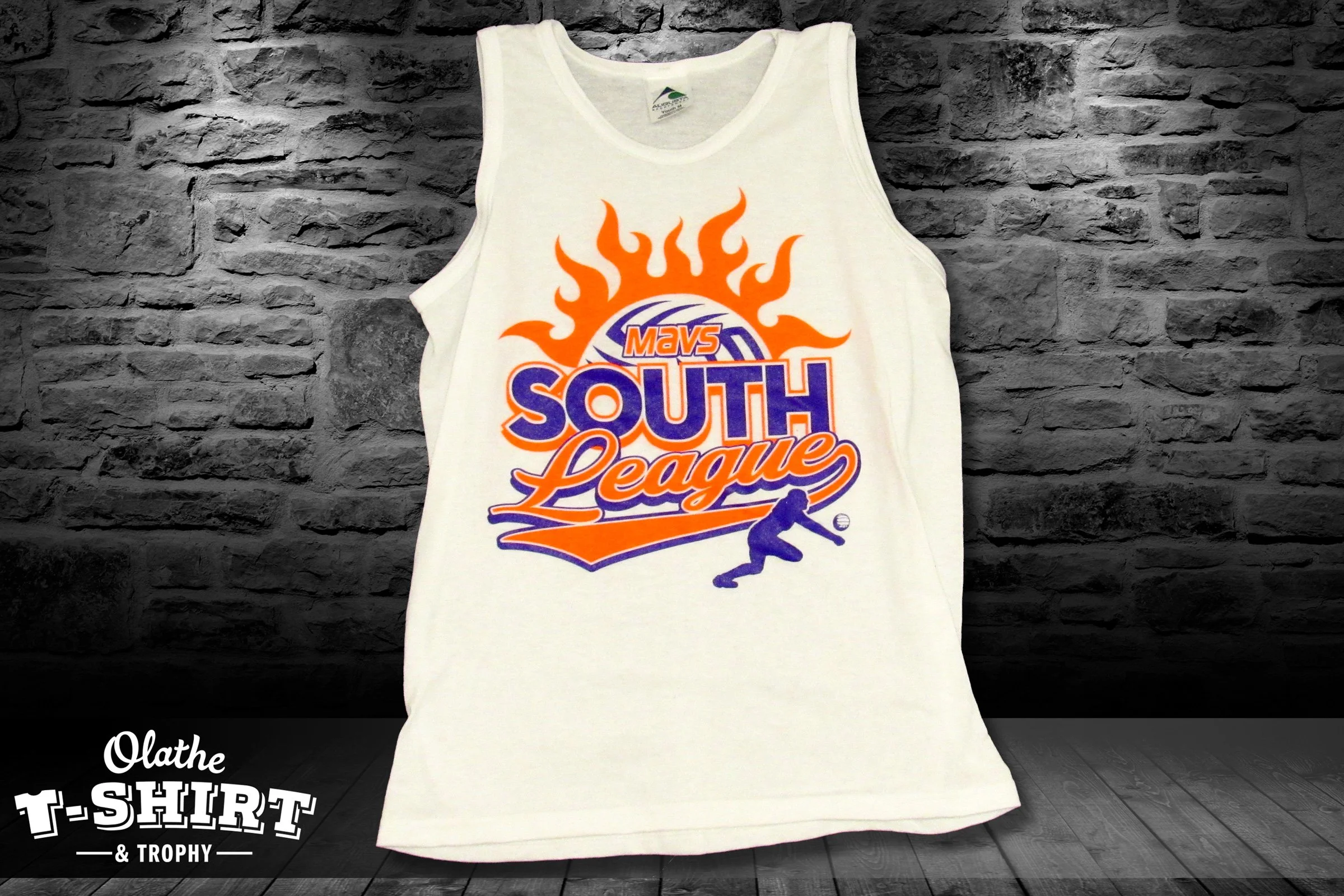 White tank top with a colorful sports graphic, displayed against a dark brick wall.