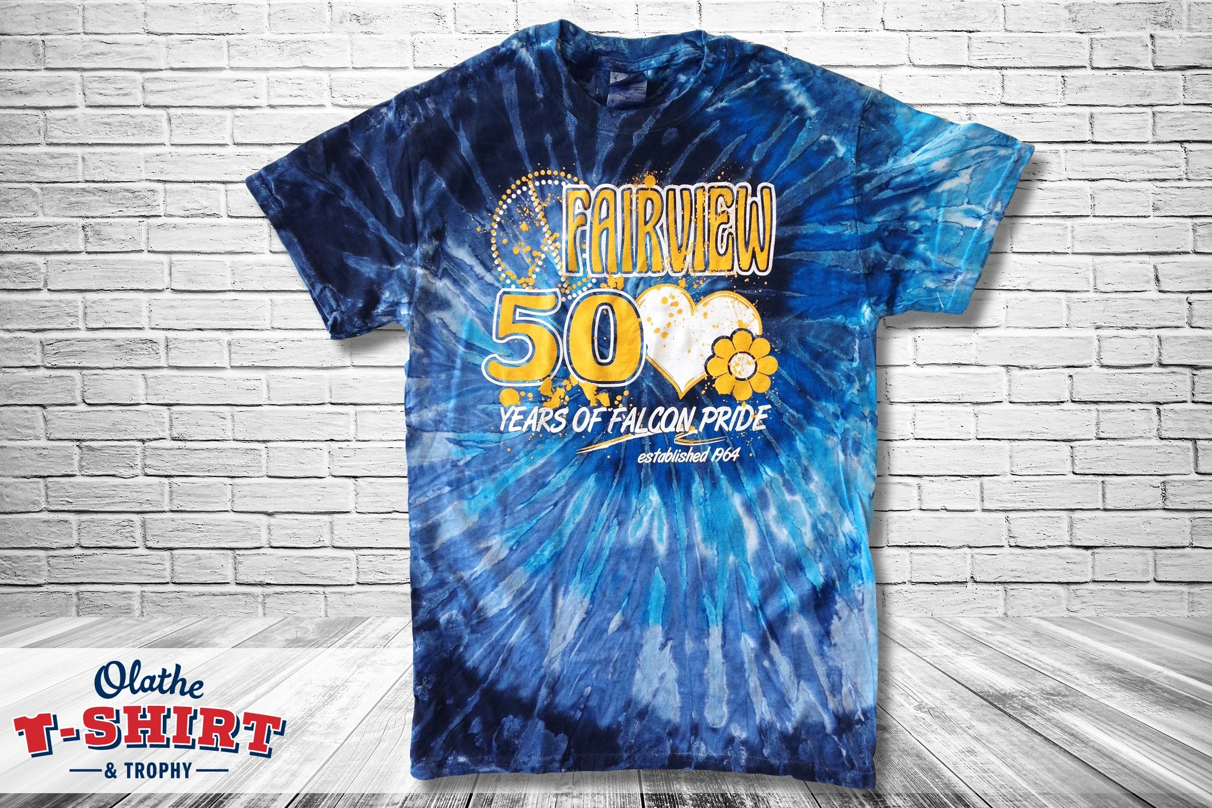 Blue tie-dye Falcons anniversary shirt with yellow and white lettering.