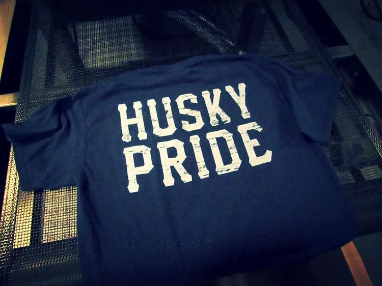 A navy blue T-shirt with the words "HUSKY PRIDE" printed in white on the front.