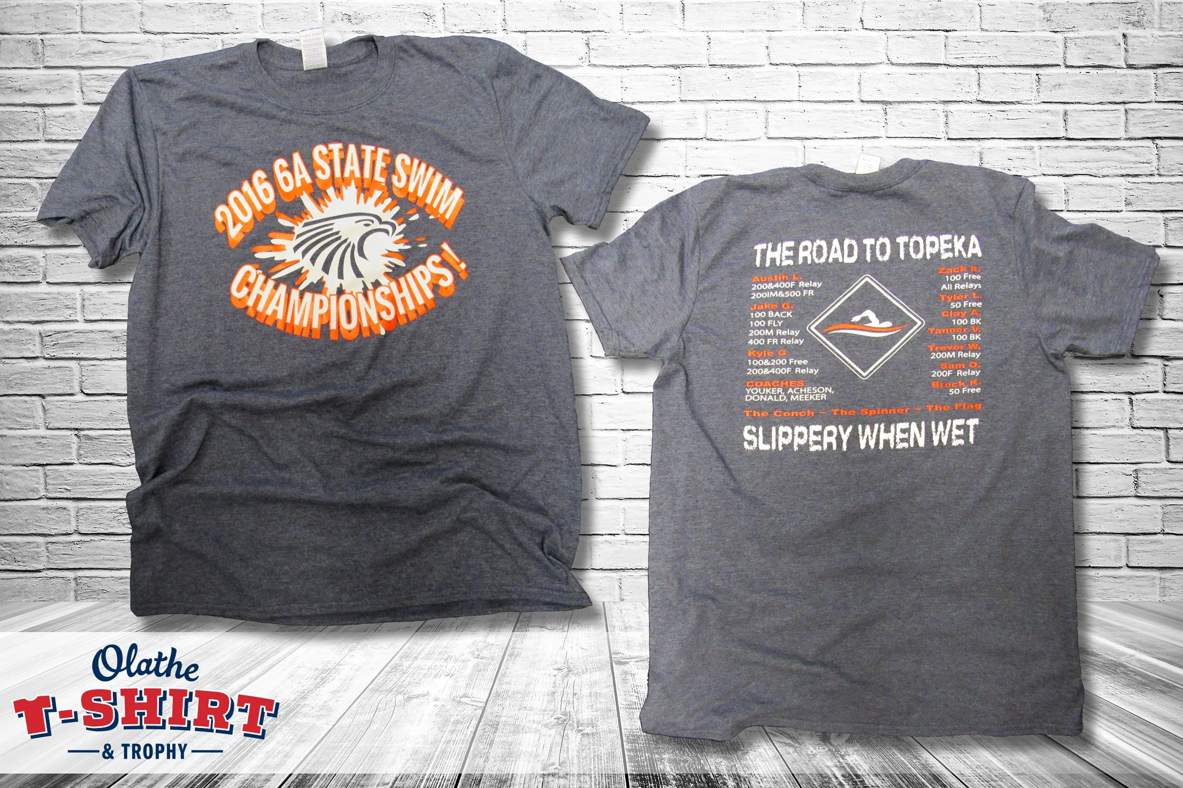 Gray state swim championship shirt with orange lettering and a mascot graphic.