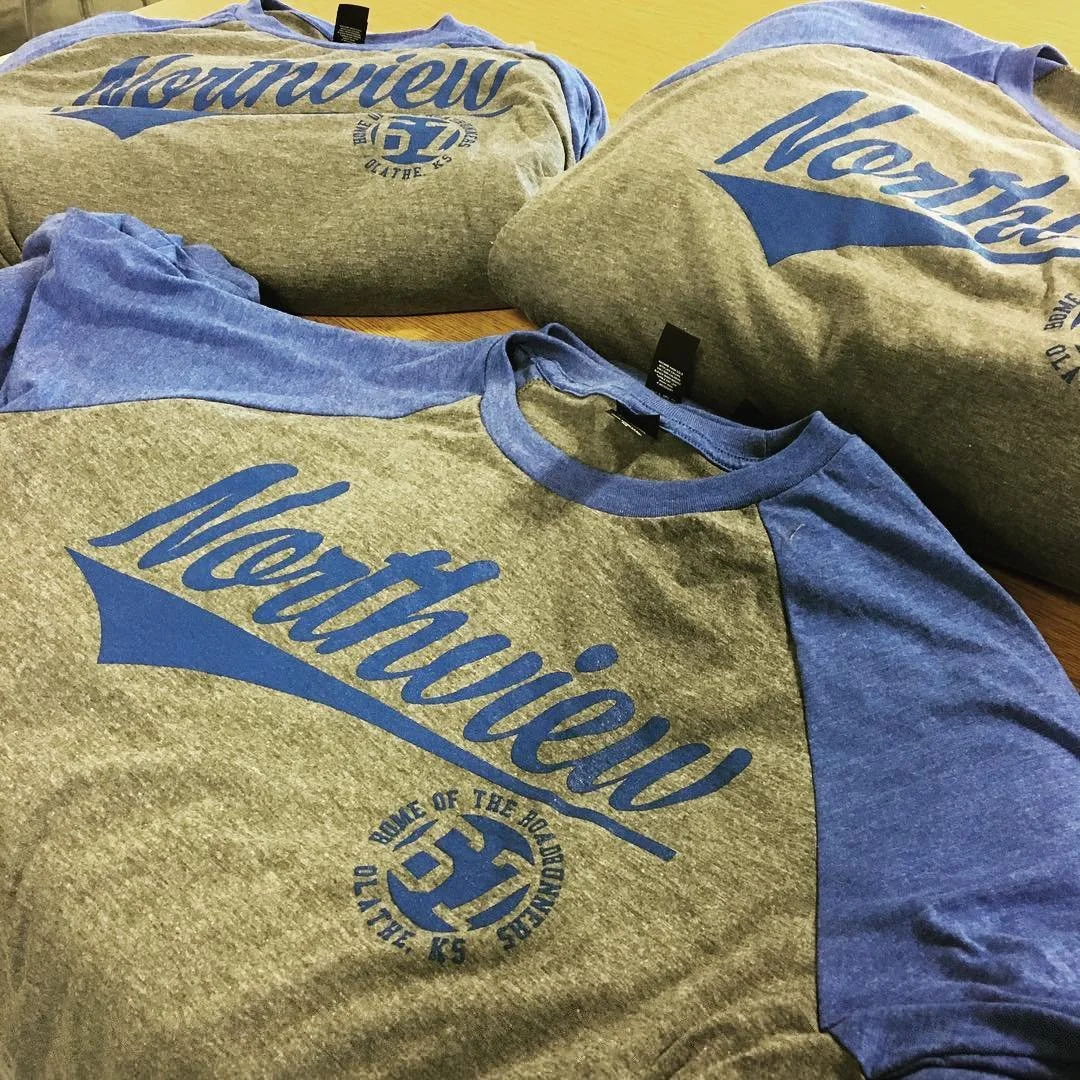 Gray and blue school sweatshirts with coordinating printed logos.
