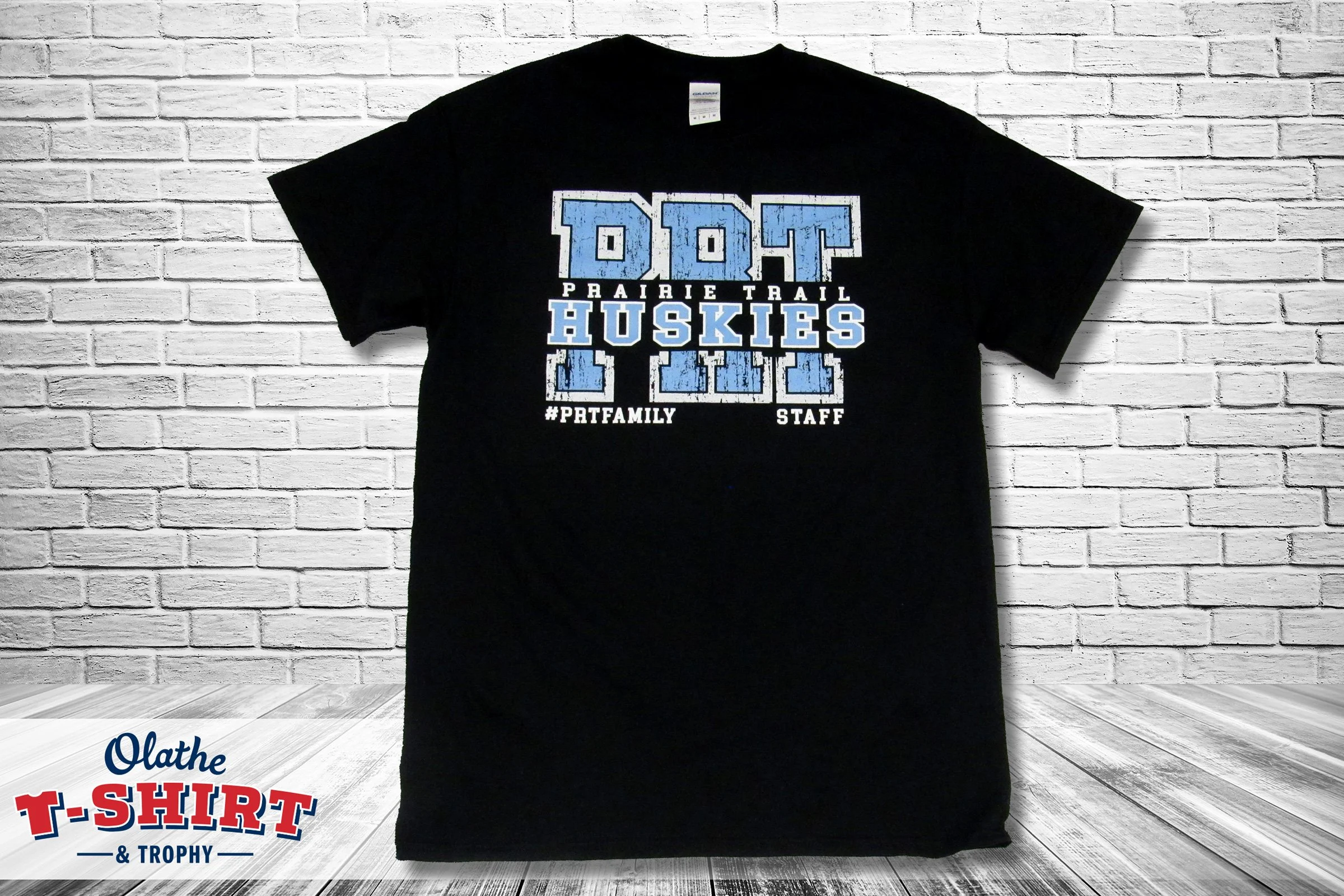 Black Prairie Trail shirt with blue and white school graphics.