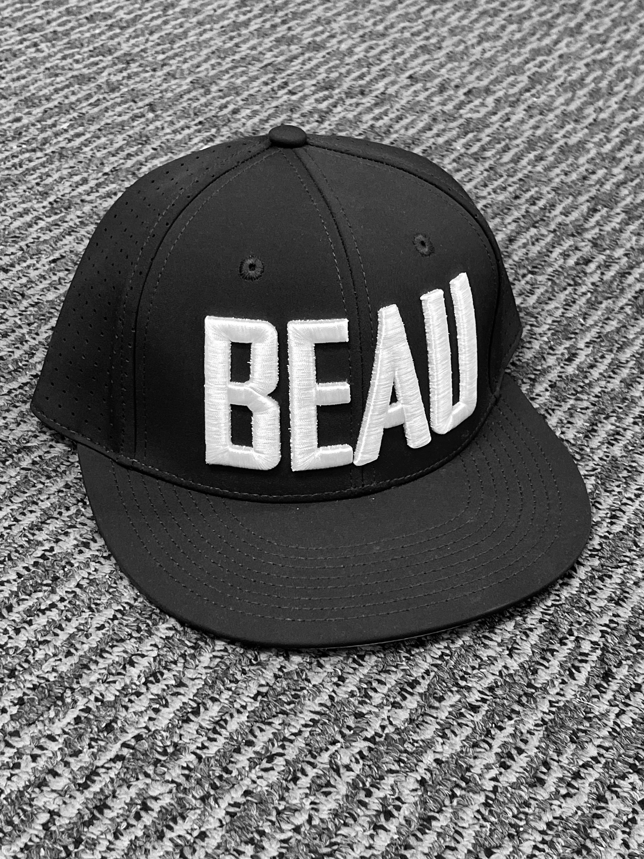 Black baseball cap with large white embroidered lettering.